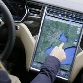 In a photo from Tuesday, April 7, 2015 in Detroit, Alexis Georgeson of Tesla Motors, shows off the navigation screen of the new Tesla Model S 70D during a test drive. Electric car maker Tesla Motors is seeking mainstream luxury buyers by adding all-wheel-drive and more range and power to the base version of its only model. Starting Wednesday, Tesla will stop selling the old base Model S called the 60 and replace it with the 70-D. The new car can go 240 miles per charge and from zero to 60 in 5.2 seconds. (AP Photo/Carlos Osorio)