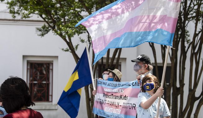 Protestors in support of transgender rights rally outside the Alabama State House in Montgomery, Ala., March 30, 2021. Three days after the U.S. Supreme Court ruled that states can prohibit abortion, Alabama seized on the decision to argue that the state should also be able to ban gender-affirming medical treatments for transgender youth. (Jake Crandall/The Montgomery Advertiser via AP, File)