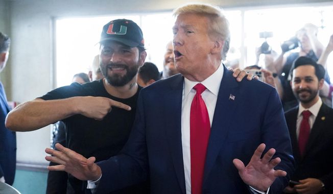 UFC fighter Jorge Masvidal gestures toward former President Donald Trump as he visits Versailles restaurant on Tuesday, June 13, 2023, in Miami. Trump appeared in federal court Tuesday on dozens of felony charges accusing him of illegally hoarding classified documents and thwarting the Justice Department&#x27;s efforts to get the records back. (AP Photo/Alex Brandon)