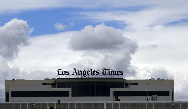 The Los Angeles Times building is seen behind a fence behind the Los Angeles International Airport, Friday, April 10, 2020. (AP Photo/Richard Vogel, File)