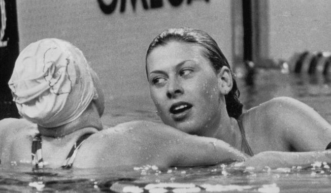 Sharron Davies of England, right, receives congratulations from Lisa Curry of Australia, after she had won the Gold medal for the Women&#x27;s 200metres Individual Medley, during the 11th Commonwealth Games, in the Aquatic Center, Edmonton, Canada on Aug. 5, 1978. (AP Photo)