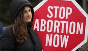 Kinga Gebauer holds a sign in front of the Walgreens corporate headquarters during a protest over a plan to sell abortion pills at Walgreens Deerfield Headquarters in Deerfield, Ill., Tuesday, Feb. 14, 2023. An Associated Press-NORC Center poll found that most U.S. adults favor allowing abortion at least in the early weeks of pregnancy. (AP Photo/Nam Y. Huh, File)