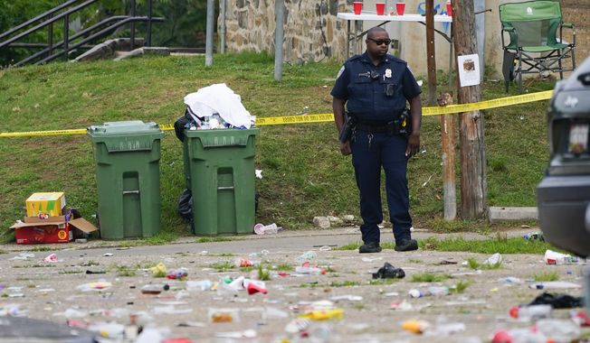 A police officer stands in the area of a mass shooting incident in the Southern District of Baltimore, Sunday, July 2, 2023. Baltimore leaders are condemning what they called a “catastrophic breakdown” in how city police responded to 911 calls leading up to a mass shooting at a neighborhood block party earlier this month. Police received a call about hundreds of partygoers armed with guns and knives about three hours before the shooting, but on-duty officers decided no law enforcement services were required.(AP Photo/Julio Cortez, File)
