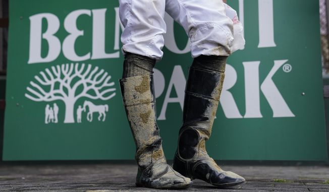 A jockey&#x27;s boots are caked in mud after an early race ahead of the Belmont Stakes horse race, Saturday, June 10, 2023, at Belmont Park in Elmont, N.Y. (AP Photo/John Minchillo)