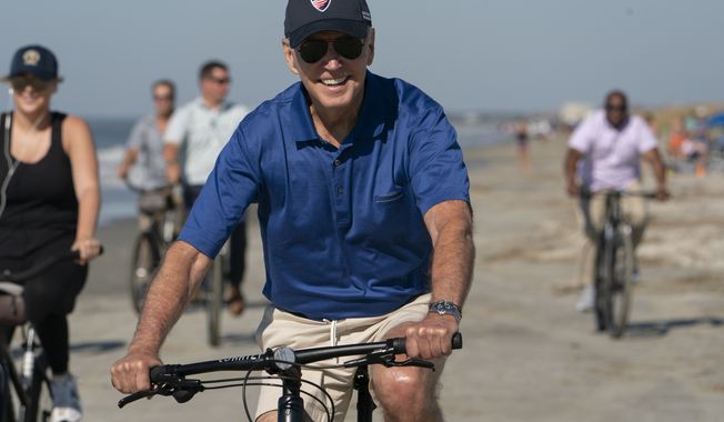 President Biden rides a bicycle along the beach at Kiawah Island, S.C., Sunday, Aug. 14, 2022. (AP Photo/Manuel Balce Ceneta)
