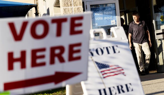 Signs and voters are many outside an election polling site in Cranston, R.I., on Nov. 7, 2022. (AP Photo/David Goldman, File)