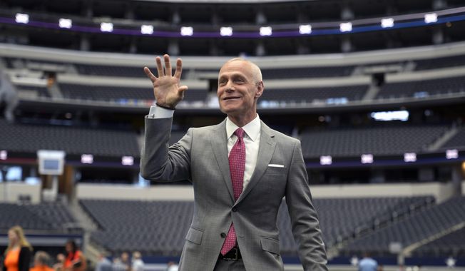 Big 12 Commissioner Brett Yormark indulges a student media outlet with a Baylor Bear hand sign before speaking at the opening of the NCAA college football Big 12 media days in Arlington, Texas, Wednesday, July 12, 2023. (AP Photo/LM Otero)