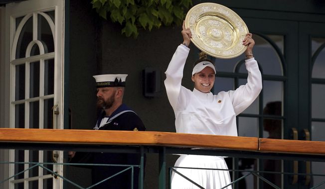 Czech Republic&#x27;s Marketa Vondrousova celebrates as she shows the trophy from the balcony of Centre Court after beating Tunisia&#x27;s Ons Jabeur to win the final of the women’s singles on day thirteen of the Wimbledon tennis championships in London, Saturday, July 15, 2023. (Victoria Jones/PA via AP)