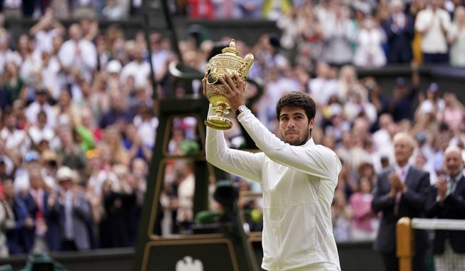 Spain&#x27;s Carlos Alcaraz celebrates with his trophy after beating Serbia&#x27;s Novak Djokovic in the men&#x27;s singles final on day fourteen of the Wimbledon tennis championships in London, Sunday, July 16, 2023. (AP Photo/Alberto Pezzali)