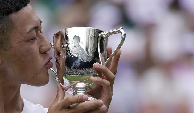 Japan&#x27;s Tokito Oda celebrates with the trophy after beating Britain&#x27;s Alfie Hewitt to win the final of the men&#x27;s wheelchair singles on day fourteen of the Wimbledon tennis championships in London, Sunday, July 16, 2023. (AP Photo/Kin Cheung)