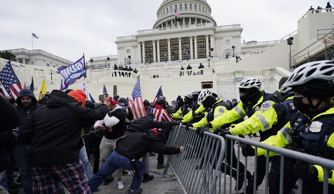 Rioters supporting President Donald Trump try to break through a police barrier at the Capitol in Washington, on Jan. 6, 2021. (AP Photo/Julio Cortez) **FILE**