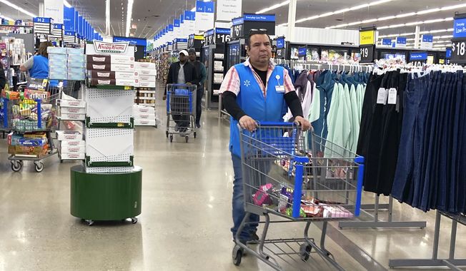 An employee pushes a cart at a Walmart in Vernon Hills, Ill., Tuesday, March 28, 2023. (AP Photo/Nam Y. Huh, File)