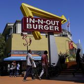 People walk below an In-N-Out Burger restaurant sign in San Francisco, Thursday, Aug. 25, 2022. (AP Photo/Jeff Chiu, File)