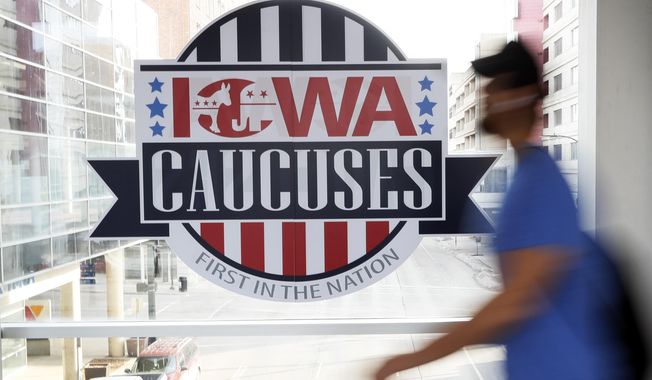 A pedestrian walks past a sign for the Iowa Caucuses on a downtown skywalk, in Des Moines, Iowa, on Feb. 4, 2020. Iowa Republicans have scheduled the party’s presidential nominating caucuses for Jan. 15, 2024, putting the first votes of the next election a little more than six months away. (AP Photo/Charlie Neibergall, File)
