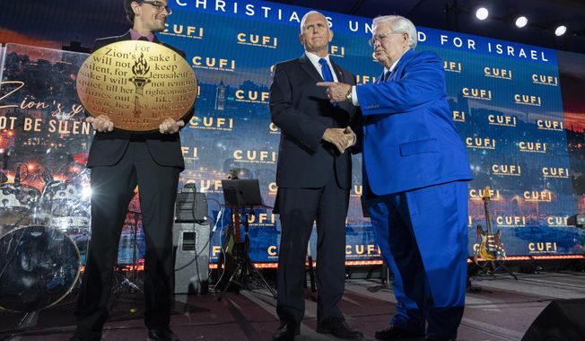 Republican presidential candidate former Vice President Mike Pence, center, is awarded the &quot;Defender of Israel&quot; award by Pastor John Hagee, right, Christians United For Israel (CUFI) Founder and Chairman, at a CUFI Night to Honor Israel event, during the CUFI Summit 2023, Monday, July 17, 2023, in Arlington, Va., at the Crystal Gateway Marriott. (AP Photo/Jacquelyn Martin)