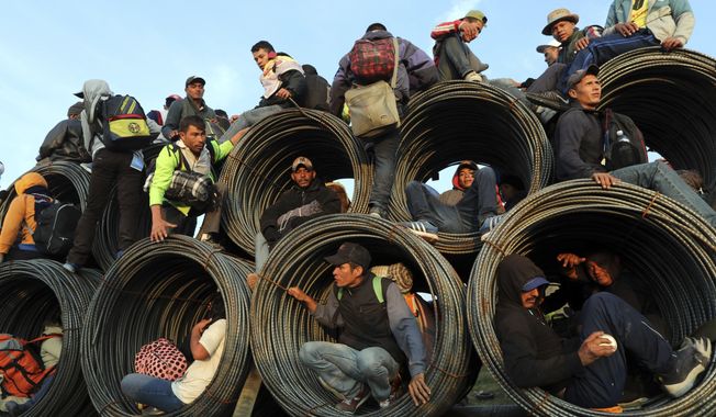 Central American migrants, part of the caravan hoping to reach the U.S. border, get a ride on a truck carrying rolls of steel rebar, in Irapuato, Mexico, Nov. 12, 2018, after a month on the road. (AP Photo/Rodrigo Abd) **FILE**