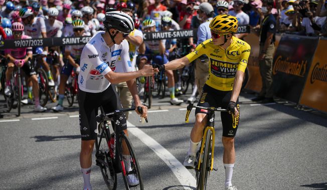 Denmark&#x27;s Jonas Vingegaard, wearing the overall leader&#x27;s yellow jersey, and Slovenia&#x27;s Tadej Pogacar, wearing the best young rider&#x27;s white jersey, pump fists prior to the seventeenth stage of the Tour de France cycling race over 166 kilometers (103 miles) with start in Saint-Gervais Mont-Blanc and finish in Courchevel, France, Wednesday, July 19, 2023. (AP Photo/Daniel Cole)