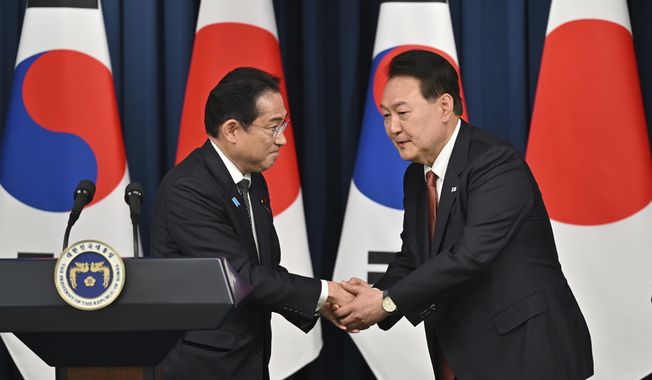 South Korean President Yoon Suk Yeol, right, shakes hands with Japanese Prime Minister Fumio Kishida during a joint press conference after their meeting at the presidential office in Seoul, on May 7, 2023. (Jung Yeon-je/Pool Photo via AP, File)