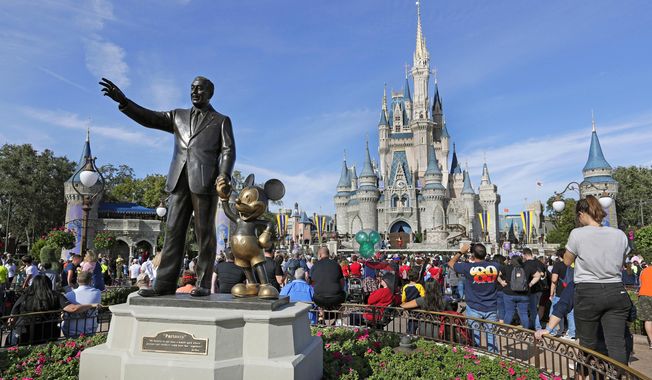 A statue of Walt Disney and Micky Mouse stands in front of the Cinderella Castle at the Magic Kingdom at Walt Disney World in Lake Buena Vista, Fla., Jan. 9, 2019. (AP Photo/John Raoux, File)