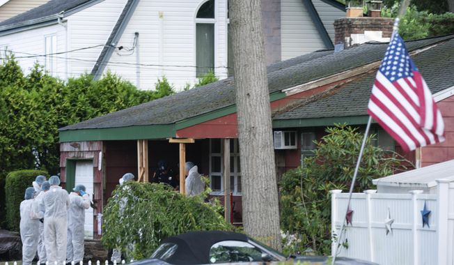 Crime laboratory officers arrive to the house where a suspect has been taken into custody on New York&#x27;s Long Island in connection with a long-unsolved string of killings, on Friday, July 14, 2023, in New York. (AP Photo/Eduardo Munoz Alvarez)