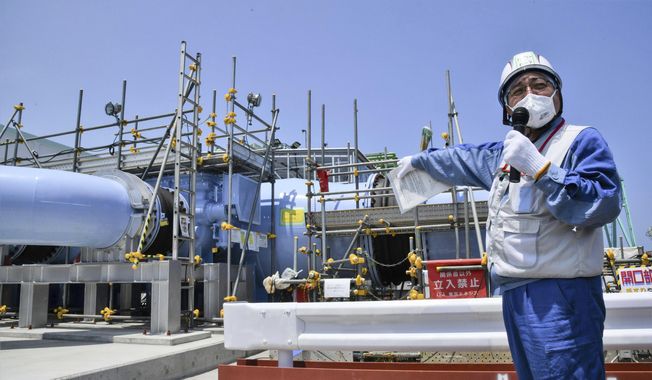 An employee of Tokyo Electric Power Company explains to the media about the facility to be used to release treated radioactive water at Fukushima Daiichi nuclear power plant in Fukushima, northern Japan, on June 26, 2023. Hong Kong&#x27;s leader warned Tuesday, July 11, that the city will ban marine products from “a large number prefectures” if Japan discharges treated radioactive wastewater into the sea. (Kyodo News via AP, File)