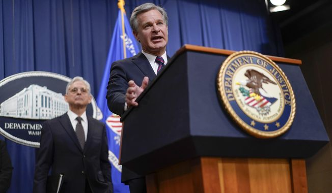 Attorney General Merrick Garland, left, listens as FBI Director Christopher Wray speaks at the Department of Justice in Washington, Friday, Jan. 27, 2023, to discuss recent law enforcement action in transnational security threats case. (AP Photo/Carolyn Kaster) **FILE**