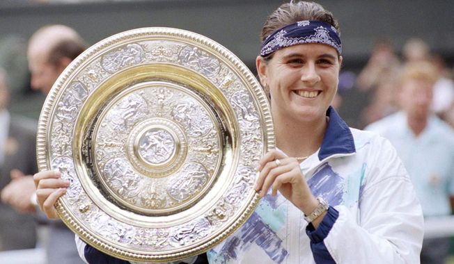FILE - Conchita Martinez holds up the trophy after winning the Ladies Singles Final on the Centre Court at Wimbledon, July 2, 1994. Former Wimbledon champion Conchita Martínez has been named tournament director for the Billie Jean King Cup finals. Twelve national teams will play in Seville during the finals from Nov. 7-12. (AP Photo/Dave Caulkin, File)