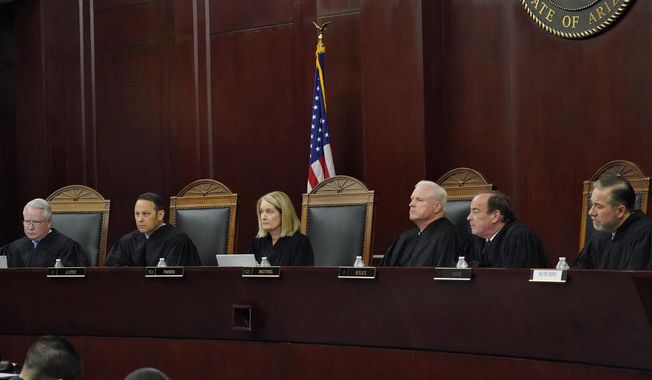 In this file photo from April 20, 2021, the Arizona Supreme Court listens to oral arguments in Phoenix. The justices from left; William G. Montgomery, John R Lopez IV, Vice Chief Justice Ann A. Scott Timmer, Chief Justice Robert M. Brutinel, Clint Bolick and James Beene.  (AP Photo/Matt York, File)  **FILE**