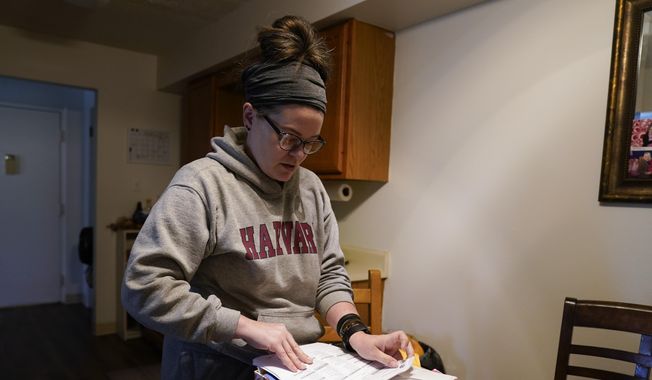 Samantha Richards looks over her Medicaid papers, Friday, June 9, 2023, in Bloomington, Ind. Richards has been on Medicaid her whole life and currently works two part-time jobs as a custodian. (AP Photo/Darron Cummings)