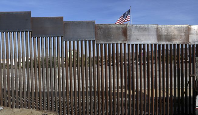 A United States flag flies behind the border fence that divides Mexico and the U.S., in Tijuana, Mexico, Nov. 21, 2018. Nearly a thousand migrants that recently crossed from Guatemala into Mexico formed a group Saturday, July 15, 2023, to head north together in hopes of reaching the border with the United States. (AP Photo/Rodrigo Abd, File)