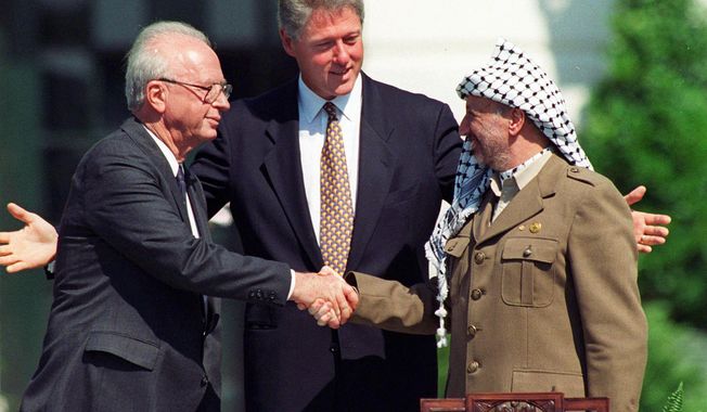 FILE - In this Sept. 13, 1993 file photo President Clinton presides over White House ceremonies marking the signing of the peace accord between Israel and the Palestinians with Israeli Prime Minister Yitzhak Rabin, left, and Palestinian leader Yasser Arafat, right, in Washington.  Two years after the groundbreaking handshake on the White House lawn between the two men, Rabin was killed by an Israeli extremist opposed to peace negotiations with the Palestinians at a rally promoting the accords. (AP Photo/Ron Edmonds, File)