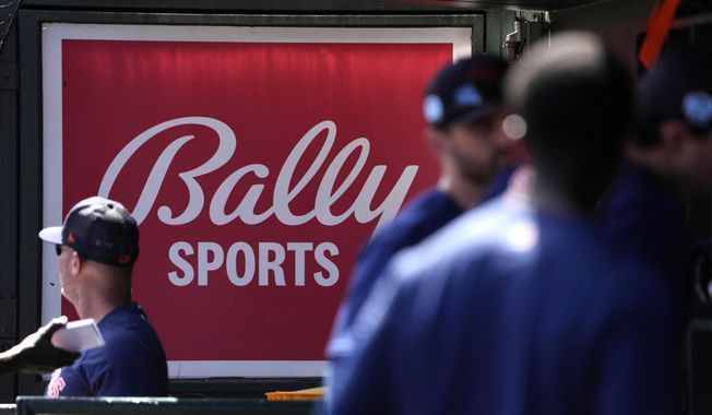 A Bally Sports sign hangs in a dugout before the start of a spring training baseball game between the St. Louis Cardinals and Houston Astros Thursday, March 2, 2023, in Jupiter, Fla. Major League Baseball says teams have collected 94% of the money they have been owed by Diamond Sports. The company owns 19 networks under the Bally Sports banner and has been in Chapter 11 bankruptcy proceedings in Texas since March. MLB took over rights to San Diego Padres telecasts on May 31 after a rights payment was missed.(AP Photo/Jeff Roberson, File)