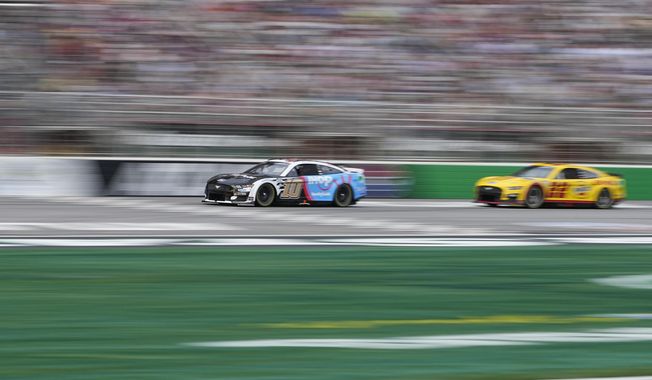 Drivers Aric Almirola (10) and Joey Logano (22) lead during a NASCAR Cup Series auto race at Atlanta Motor Speedway on Sunday, July 9, 2023, in Hampton, Ga. (AP Photo/Brynn Anderson)