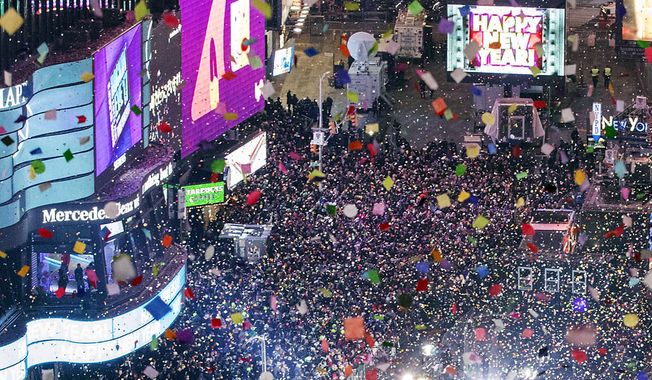 Revelers celebrate the new year as confetti flies over New York&#x27;s Times Square as seen from the Marriott Marquis, Sunday, Jan. 1, 2017. (AP Photo/Mary Altaffer)
