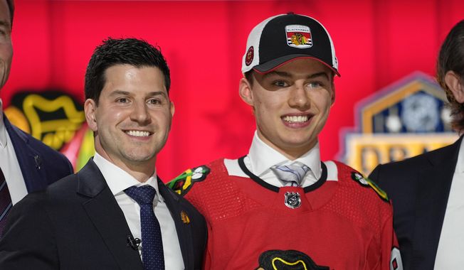 Chicago Blackhawks general manager Kyle Davidson poses with first round draft pick Connor Bedard during the first round of the NHL hockey draft, Wednesday, June 28, 2023, in Nashville, Tenn. (AP Photo/George Walker IV)
