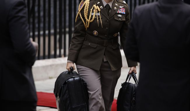 A military aide carries the Presidential Emergency Satchel, also known as the &quot;nuclear football,&quot; out of 10 Downing Street in London on Monday, July 10, 2023, after a meeting between Prime Minister Rishi Sunak and U.S. President Joe Biden. The bulky briefcase contains atomic war plans and enables the president to transmit nuclear orders to the Pentagon. The heavy case is carried by a military officer who is never far behind the president. (AP Photo/David Cliff)