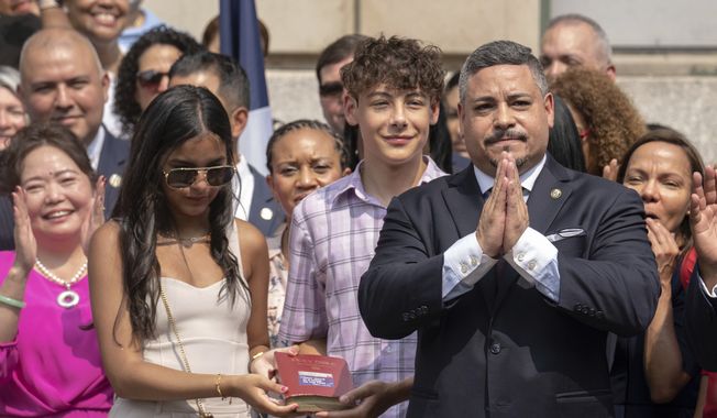 NYPD Police Commissioner Edward A. Caban, right, is sworn in during a ceremony outside New York City Police Department 40th Precinct on Monday, July 17, 2023, in New York. (AP Photo/Jeenah Moon)