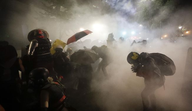 FILE - Federal officers launch tear gas at a group of demonstrators during a Black Lives Matter protest in Portland, Ore., on July 26, 2020. Oregon&#x27;s reputation for political harmony is being tested as a Republican walkout in the state Senate continues for a third week. The boycott could derail hundreds of bills and approval of a biennial state budget, as Republicans and Democrats refuse to budge on their conflicting positions over issues including abortion rights, transgender health and guns. (AP Photo/Marcio Jose Sanchez, File)