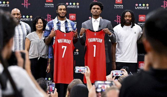 Houston Rockets NBA basketball first-round draft picks Cam Whitmore (7) and Amen Thompson (1) pose with family for a photo during a news conference at the Toyota Center in Houston, Monday, June 26, 2023. (AP Photo/Maria Lysaker)