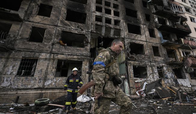 Ukrainian soldiers and firefighters search in a destroyed building after a bombing attack in Kyiv, Ukraine, Monday, March 14, 2022. (AP Photo/Vadim Ghirda) **FILE**