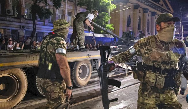 Members of the Wagner Group military company guard an area as others load their tank onto a truck on a street in Rostov-on-Don, Russia, Saturday, June 24, 2023, prior to leaving an area at the headquarters of the Southern Military District. Russia&#x27;s rebellious mercenary chief Yevgeny Prigozhin walked free from prosecution for his June 24 armed mutiny. In the meantime, a campaign appears to be underway to portray the founder of the Wagner Group military contractor as driven by greed. (Vasily Deryugin, Kommersant Publishing House via AP) **FILE**