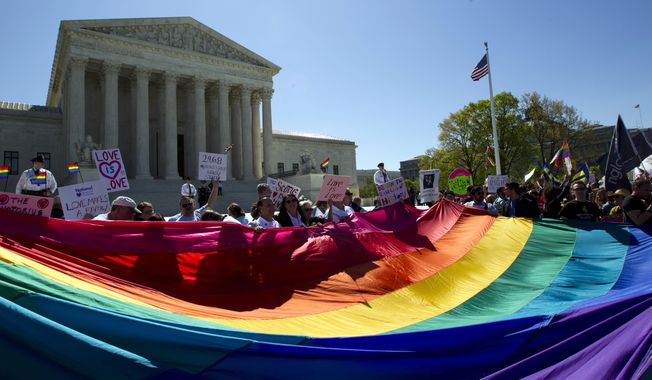 In this April 28, 2015 file photo, demonstrators stand in front of a rainbow flag of the Supreme Court in Washington. In 2019, there were slightly less than 1 million same-sex couple households in the U.S., and a majority of those couples were married. New figures released Thursday, Sept. 17, 2020 by the U.S. Census Bureau shows that of the 980,000 same-sex couple households, 58% were married couples and 42% were unmarried partners. (AP Photo/Jose Luis Magana, File)