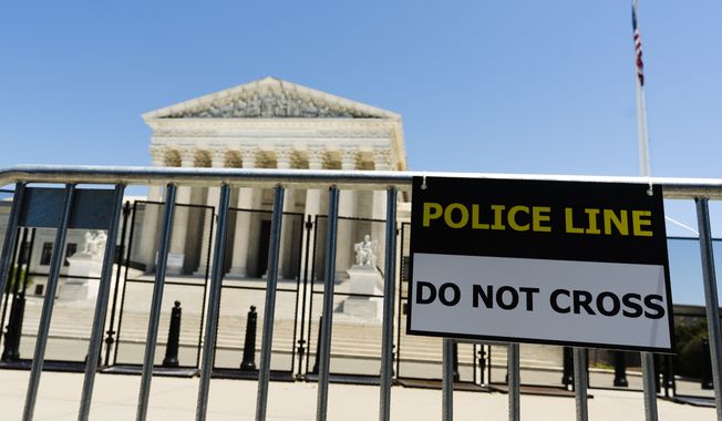Two rows of metal security fencing are erected outside the U.S. Supreme Court, Sunday, June 5, 2022, in Washington. (AP Photo/Manuel Balce Ceneta)