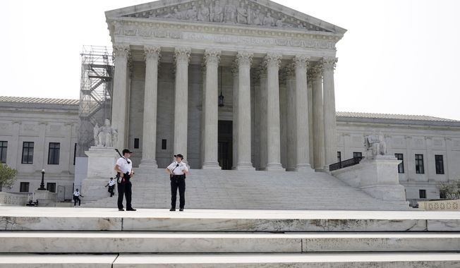 Officers stand guard outside of the Supreme Court on Friday, June 30, 2023, as decisions are expected in Washington. (AP Photo/Mariam Zuhaib)
