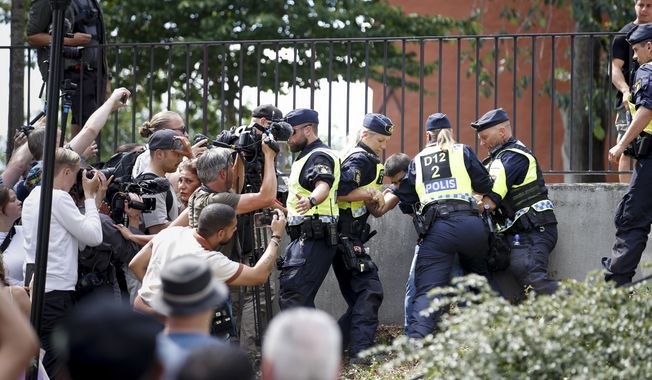 Police members try to restrain a man outside Stockholm&#x27;s mosque at Medborgarplatsen, Sweden, Wednesday June 28, 2023. Stockholm police on Friday July 14, 2023 said they have authorized a protest this weekend by a man who has stated that he wants to burn the Torah and the Bible outside the Israeli Embassy in Stockholm. (Caisa Rasmussen/TT News Agency via AP)