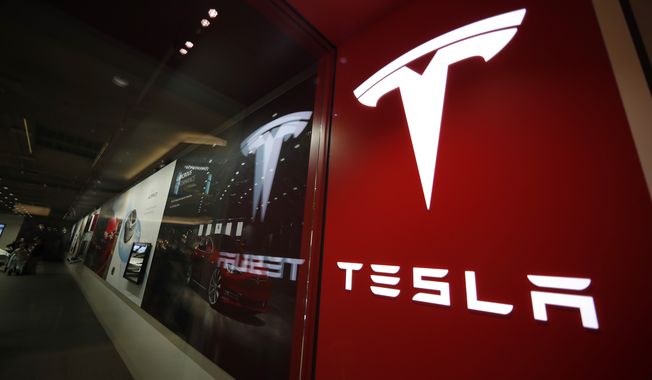A sign bearing the Tesla company logo is displayed outside a Tesla store in Cherry Creek Mall in Denver, Feb. 9, 2019. Current and former directors of electric-vehicle maker Tesla Inc. have agreed to return more than $735 million to the company to settle a shareholder lawsuit alleging that they unjustly enriched themselves with excessive compensation. The proposed settlement was outlined in documents filed late Friday, July 14, 2023, in the Delaware Court of Chancery and is subject to court approval. (AP Photo/David Zalubowski, File)