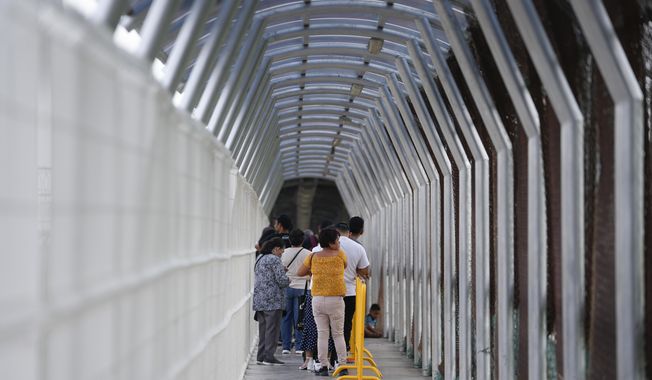 Travelers wait in line to cross the McAllen-Hidalgo International Bridge, Friday, May 12, 2023, in Hidalgo, Texas. (AP Photo/Julio Cortez)