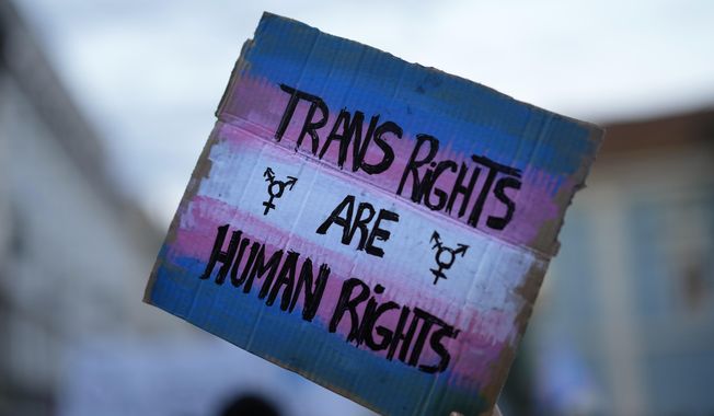 A demonstrator holds up a sign during a march to mark International Transgender Day of Visibility in Lisbon, March 31, 2022. At least 32 transgender and gender-nonconforming people have been killed in the United States in 2022, the Human Rights Campaign announced Wednesday, Nov. 16, in its annual report ahead of Transgender Day of Remembrance on Sunday, Nov. 20. (AP Photo/Armando Franca, File)