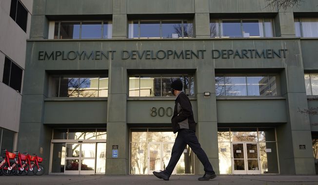 In this Dec. 18, 2020, file photo, a person passes the office of the California Employment Development Department in Sacramento, Calif. Some Americans are receiving tax forms saying they owe money on unemployment benefits they never received. The notices from state governments could be a sign of the extent of identity theft in the nation&#x27;s state-run unemployment systems. Unemployment benefits are taxable, so government agencies must send a tax form to people who received them. (AP Photo/Rich Pedroncelli, File)