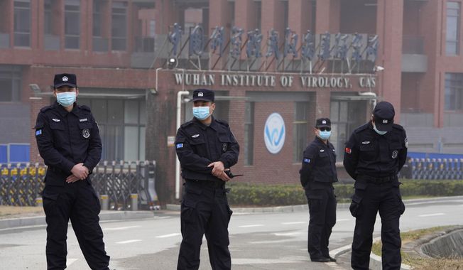 In this file photo, security personnel gather near the entrance of the Wuhan Institute of Virology during a visit by the World Health Organization team in Wuhan in China&#x27;s Hubei province on Wednesday, Feb. 3, 2021. (AP Photo/Ng Han Guan) ** FILE **